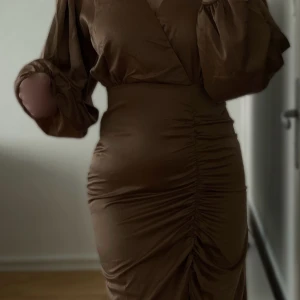 Helt ny, oanvänd Brun klänning - Storlek M (små i storleken, passar XS och S)  Helt ny, oanvänd. Prislapp kvar! Fler bilder kan skickas vid intresse 