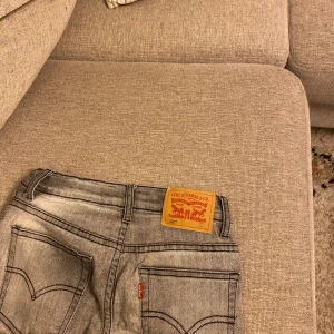 Grå Levis 502 jeans - Säljer ett par grå Levis 502 jeans med regular taper passform. Klassisk design med fem fickor och knappgylf. Perfekta för en avslappnad stil.