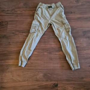 Beige cargobyxor - Säljer ett par beige cargobyxor från KappAhl med elastisk midja och muddar vid bensluten.