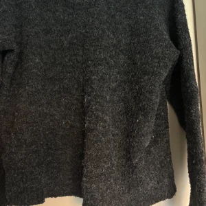 Mörkgrå stickad tröja från Lager157 - Säljer en mysig mörkgrå stickad tröja från Lager157. Tröjan har en enkel design med långa ärmar och rund hals. Perfekt för kyliga dagar.