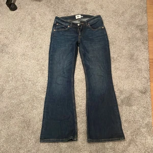Blå bootcut jeans från 157 - Snygga blå bootcut jeans från 157 med låg midja. Klassisk femficksdesign och dragkedja med knapp framtill. Perfekta för en avslappnad stil. Modellen heter ”Low boot”