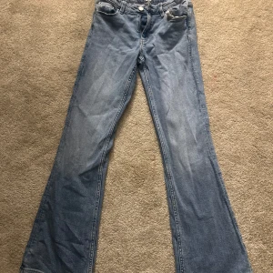 Blå jeans från Gina Tricot - Snygga blå jeans från Gina Tricot med bootcut-stil. Klassisk femficksdesign och knappgylf. Passar bra till både sneakers och klackar. Skrynkliga nu men helt oanvända