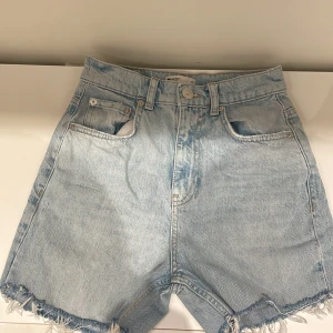 Ljusblå jeansshorts med fransar - Säljer ett par ljusblå jeansshorts från ginatricot. perfekta för sommaren.