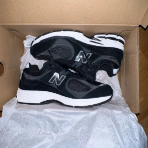 Svarta sneakers från New Balance - Snygga svarta sneakers från New Balance med vit sula och klassisk N-logga på sidan. Skorna har en sportig design med meshdetaljer för extra andningsförmåga och komfort. Perfekta för både träning och vardag.