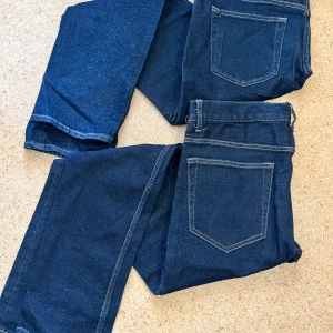 Mörkblå jeansbyxor - Snygga mörkblå jeansbyxor med klassisk femficksdesign. Byxorna har en rak passform och är perfekta för en avslappnad stil. De är tillverkade i ett slitstarkt denimtyg och har en bekväm midwaist. En är i storlek 32/32 och en är i storlek 33/30