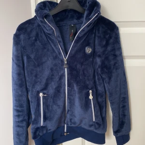 Mörkblå fleecejacka från Cavalliero - Säljer en mysig mörkblå rid fleecejacka från Cavalliero. Jackan har en dragkedja framtill och två praktiska fickor med dragkedjor. 