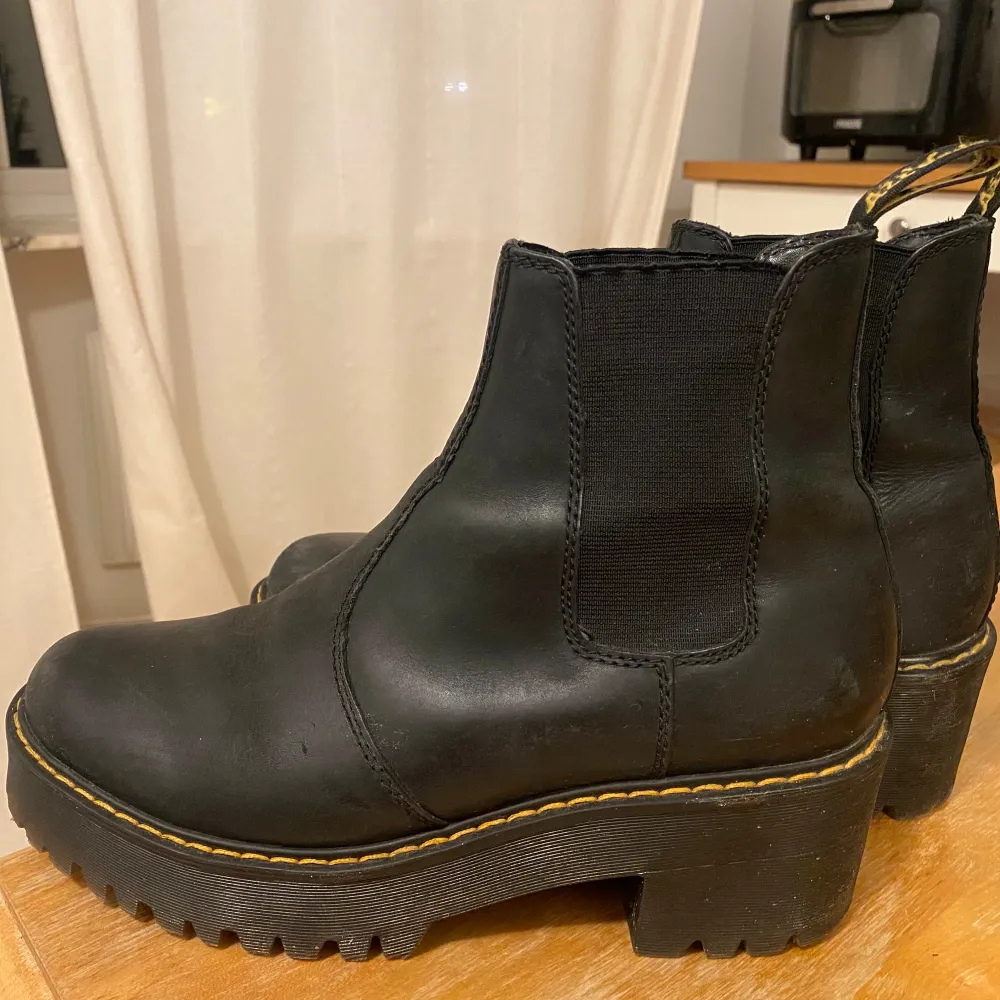 Snygga svarta Chelsea boots i skinn med robust platåsula och gul söm. Perfekta för en cool och avslappnad stil. De har en rund tå och elastiska paneler för enkel på- och avtagning.. Kengät.