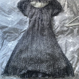 Svartvit klänning från b.young - Säljer en svartvit klänning från b.young med ett unikt mönster. Klänningen har korta ärmar och en fin passform, väldigt luftig. Storlek L, men skulle säga mer S eller M 