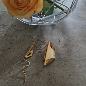 Unika guldiga statement-örhängen - Säljer ett par stora, guldiga statement-örhängen med modern, skulptural design. Ena örhänget har en vågig, lång form medan det andra är mer kompakt och geometriskt. Perfekta för dig som vill sticka ut och addera en cool touch till din stil. Har några fåtal repor.