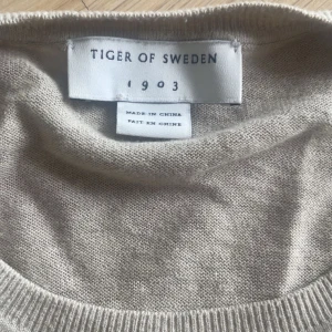 Beige stickad tröja Tiger of Sweden - Säljer en näst intill oanvänd beige Tiger of Sweden tröja. Tunn och luftig tröja perfekt på sommarkvällar. 180 cm/ 78 kg