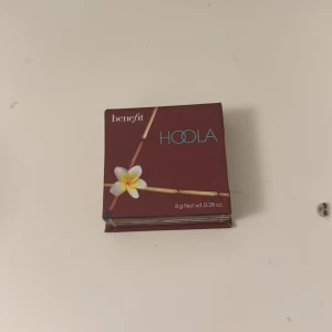 Benefit Hoola Bronzer 8g - Säljer en klassisk Hoola bronzer från Benefit i originalförpackning. Kommer i en snygg brun kartong med spegel i locket. Puderbronzer i en naturlig matt brun nyans, perfekt för att skapa solkysst look och contouring.