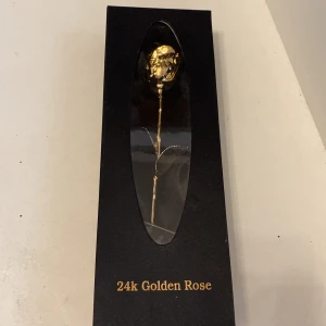 24K guldpläterad ros i presentask - Unik ros i metall pläterad med 24 karats guld, levereras i elegant svart presentask med satinliknande inredning. Rosens form är naturtrogen och glänsande, perfekt som exklusiv gåva eller dekoration. Lyxig och stilren detalj som verkligen sticker ut.