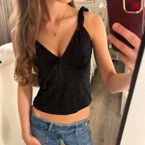 Svart linnetopp med knytband - Säljer en super söt svart sommartopp med knyte i ryggen och en liten söt rosett framtill💗älskar den här toppen (banden är lite insydda då jag tyckte dem var för långa)✨