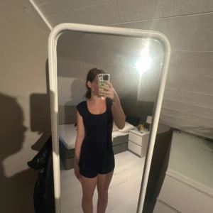 Mörkblå body med shorts med öppen rygg - Supersnygg mörkblå kort body med shorts med tight passform och öppen rygg. Bodyn med shorts har rund halsringning och är ärmlös, perfekt för dig som gillar en enkel men stilren look. Passar perfekt till varma dagar eller när du vill sticka ut lite extra.