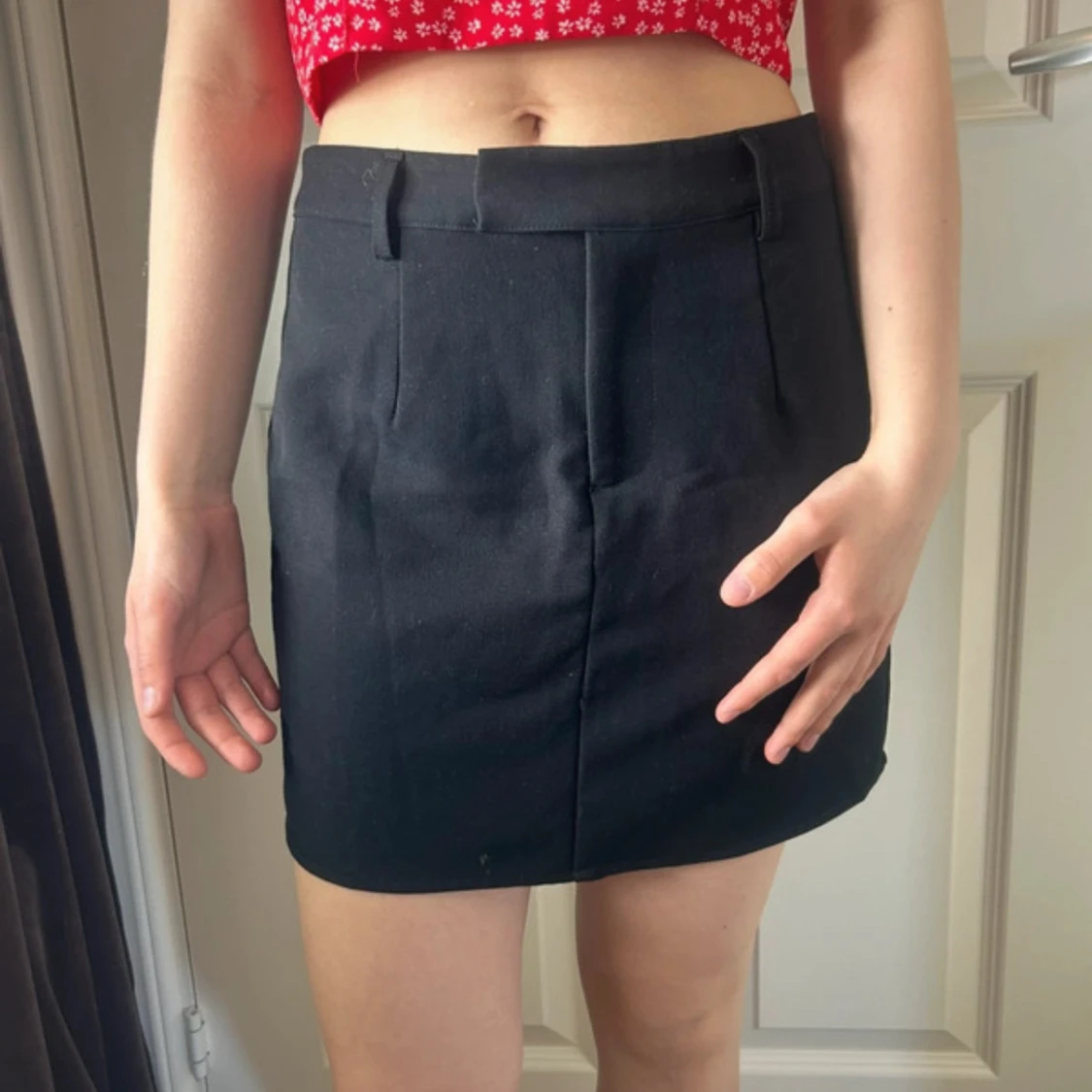 Svart kortkjol med bälteshällor