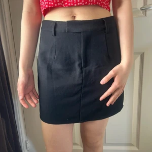 Svart kortkjol med bälteshällor - Enkel och stilren svart mini kjol, den har en rak passform och är perfekt att matcha med crop tops eller stickade tröjor. Skriv vid intresse! 🌸