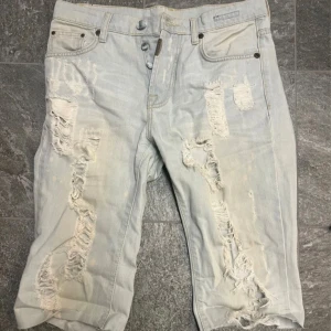 Slitna jeansskjorts  - Ripped jeansskjorts från Adrian Hammond. Storlek midja: 30