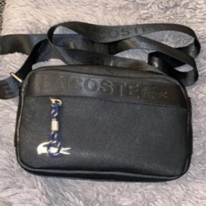 Lacoste axelväska - Perfekt Lacoste axelväska nu till sommaren! Först till kvarn 