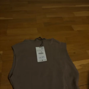 Beige ärmlös linnetopp L - Säljer en stilren beige ärmlös linnetopp i storlek L. Toppen har en enkel och clean design med rund halsringning och mjukt material som känns skönt mot huden. Perfekt att matcha med jeans eller kjol för en chill look.