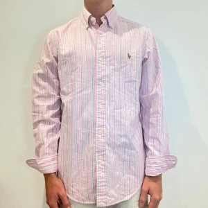 Rosa Randig Ralph Lauren Skjorta - Rosa randig Ralph lauren skjorta || Storlek S || Skjortan är i bra skick || Mitt pris 599kr || Modellen på bilden är 170cm och väger 62kg || Tveka inte på att höra av dig vid frågor eller funderingar 