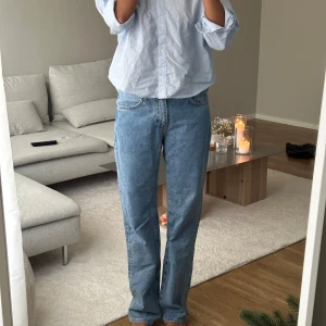 Ljusblå raka jeans - Säljer ett par ljusblå jeans med rak passform och klassisk femficksdesign. Jeansen är mid Waist. Storlek W29/L34, jag är 175cm lång 