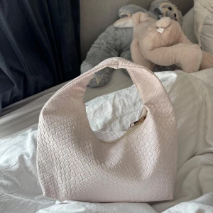 Ljusbeige axelväska med struktur - Snygg ljusbeige väska med coolt rutmönstrad struktur och dragkedja upptill. Fick nyligen i present så den är aldrig använd 