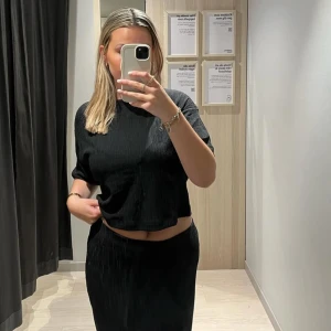 Sett med matchande kjol och topp - Croppad topp med matchande svart kjol med slits, knappt använd. Säljer som sett. 