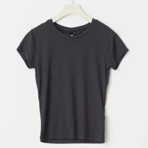 Mörkgrå t-shirt  - En mörkgrå t-shirt med tight passform. T-shirten har rund halsringning och korta ärmar. Tillverkad i mjuk bomull som känns skön mot huden. Perfekt att matcha med jeans eller kjol. Använd 1 gång