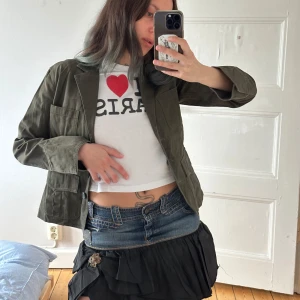 Olivgrön kavaj  - Olivgrön kavaj med klassisk krage och tre knappar framtill. Jackan har fyra stora fickor och är ganska robust. Snygg, rak passform och långärmad. Köpt second hand men aldrig använd av mig!