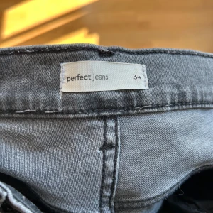 Grå bootcut jeans från Perfect Jeans - Snygga grå jeans från Perfect Jeans i storlek 34. Modellen har bootcut. Jag är runt 174