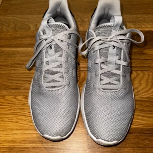 Grå adidas sneakers Neo - Snygga grå adidas sneakers med klassiska tre ränder på sidan. Ovandel i mesh. Perfekta för dig som gillar stilrena och sportiga skor och vill ha sköna och bekväma skor för långa promenader. 