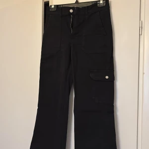 Svarta cargo jeans med raka ben - Raka ben med en ficka på sidan. Byxorna är knappt använda och är stretch. 