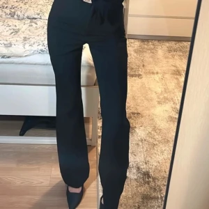 Svarta kostymbyxor.  - Snygga svarta kostymbyxor med hög midja och raka ben. Rak passform, något bootcut. Tillverkade i ett mjukt och följsamt material som ger en dressad känsla. Liten i storleken. 