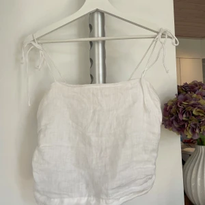 Vit linnetopp med knytband - Superfräsch vit linnetopp med tunna axelband som knyts på axlarna. Supersöt💖💖Storlek M men passar xs/s då det går att justera axelbanden!