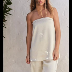 Champagnefärgad satin tubtopp zara - Säljer en stilren och lyxig axelbandslös tubtopp i champagnefärgad satin från zara💗 Helt slutsåld och populär! Använd en gång