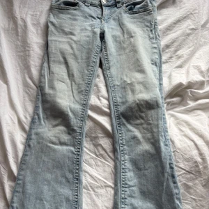 Ljusblå bootcut jeans  - Snygga ljusblå jeans med bootcut passform och klassiska femficksdetaljer. Jeansen har coola bakfickor med lock och knapp, samt en skön jeanskvalitet som passar perfekt till sneakers eller boots.