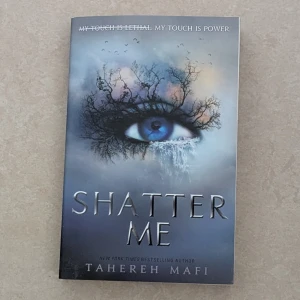 Shatter Me - En spännande ungdomsroman på engelska, 'Shatter Me' av Tahereh Mafi. Omslaget har ett blått öga med trädgrenar och fåglar, vilket ger en mystisk känsla. Boken är en del av en populär dystopisk serie och passar dig som gillar fantasy och romantik. Aldrig läst boken 