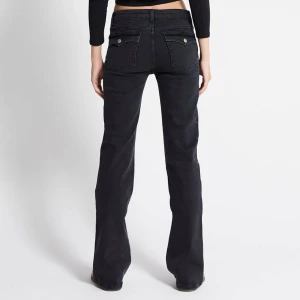 Svarta bootcut jeans - Svarta jeans med bootcut-passform och klassiska femficksdetaljer. Byxorna har normalhög midja och raka ben som blir vidare nedtill. Perfekta för en avslappnad men ändå snygg look.