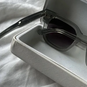 Grå chimi solglasögon med fyrkantig form - Snygga solglasögon me grå båge och mörka glas. De har en trendig, fyrkantig form och passar perfekt som accessoar till din outfit. Kommer i ett stilrent fodral. chimi 04 gråa