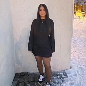 Svart glittrig kortklänning med öppen rygg - Populär klänning på tik tok. Klänningen har en öppen rygg med knytband.  ⚠️använd 1 gång,  ⚠️jag är 161 cm lång