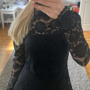 Svart spetsblus med lång ärm - Säljer en svart blus i spets. Blusen har ett vackert blommigt spetsmönster och är figurnära upptill. Perfekt för dig som vill ha en elegant och stilren look.