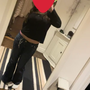 Mörkblå bootcut jeans med stjärndetalj - Säljer ett par mörkblå bootcut jeans från Victoria Beckham  med snygga stjärnor broderade på bakfickorna. Dom är low waist och i storlek w28 men passar mig som brukar ha w26-27💕. Jag har sytt ut dom till bootcut själv 💕