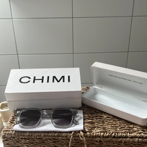 Chimi 04 grey - Snygga solglasögon från CHIMI i transparent grå plast med fyrkantig form och mörka linser. Klassisk och stilren design som passar till många tillfällen. Levereras med originaletui och putsduk.