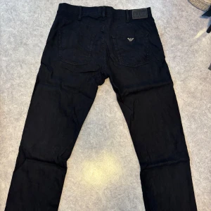 Svarta byxor från Armani Jeans - Svarta byxor från Armani Jeans med klassisk femficksdesign och diskret logga på bakfickan. Byxorna har raka ben och är i luftigt skönt tyg.