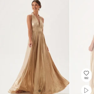 Deep V Neck Metallic Dress - Säljer en elegant guldig långklänning med djup v-ringning och bred midjedetalj. Klänningen har halterneck och öppen rygg. Klänningen är använd 1 gång tidigare och är i nyskick. Jag är 162 och klänningen är i storleken XXS. 