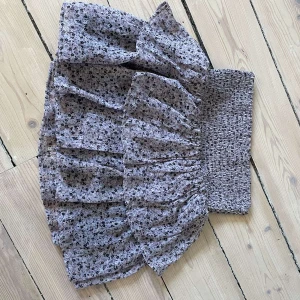 Blommig volangkjol från Kappahl - Supersöt kort volangkjol från Kappahl med småblommigt mönster i lila och svart. Kjolen har bred smock i midjan och är fodrad med svart tyg på insidan. Perfekt för dig som gillar Stockholm stil!💗Kom gärna med prisförslag!