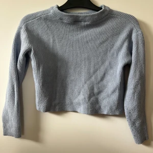 Ljusblå ribbad tröja från Name It - Säljer en ljusblå ribbad tröja från Name It. Tröjan har lång ärm och en enkel, rak passform. Perfekt för dig som gillar en stilren och basic look. Supermjuk och skön att ha på sig!