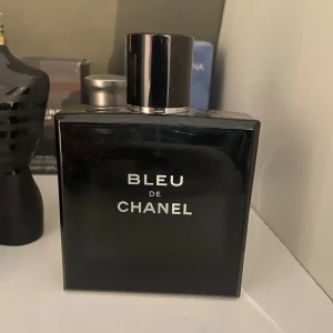 Bleu de Chanel Eau de toilette - En elegant och tidlös herrparfym från Chanel. Flaskan är fyrkantig och mörkblå med silverfärgad text och svart lock. Doften är träig och aromatisk, perfekt för dig som vill ha en klassisk och maskulin signaturdoft. Cirka 90ml kvar i flaskan, säljer då jag tycker om en annan liknande mer.