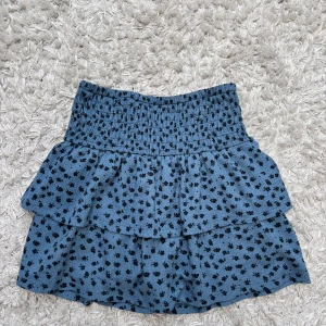 Blå kjol med volang från Zara - Supersöt blå kjol från Zara med svarta prickar och dubbla volanger. Resår i midjan och shorts i