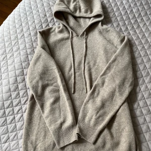 Merino ull tröja  - Sand färgad Merino ull hoodie Size M. Liten defekt i vid halsen som lätt går att sy ihop därav priset 